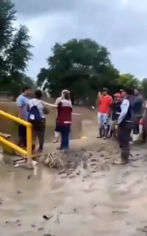 Los pobladores comenzaron a lanzarle puñados de lodo, obligándola a retirarse caminando por un puente peatonal mientras los reclamos continuaban. Captura de pantalla.